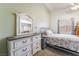 Comfortable carpeted bedroom featuring a ceiling fan, closet, and dresser with mirror at 420 Aloha Dr, Henderson, NV 89015
