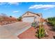 Charming single-story home featuring a two-car garage, desert landscaping, and concrete driveway at 420 Aloha Dr, Henderson, NV 89015