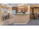 Cozy kitchen with wood cabinets, laminate flooring, granite counters, and stainless steel appliances at 420 Aloha Dr, Henderson, NV 89015