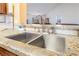 Close up of stainless steel sink with granite counters and tile backsplash at 420 Aloha Dr, Henderson, NV 89015