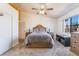 Comfortable carpeted main bedroom featuring a ceiling fan, natural light, and neutral-toned walls at 420 Aloha Dr, Henderson, NV 89015