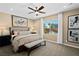 A primary bedroom with a ceiling fan, neutral walls, a king bed, carpeted floors, and a view of the backyard at 4350 E Brusca Way, Pahrump, NV 89061