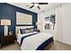 Comfortable bedroom with a blue accent wall, king bed, stylish lamps, and a carpeted floor at 4350 E Brusca Way, Pahrump, NV 89061