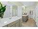 Bright bathroom with double sinks, white countertops, tiled floors, and a glass enclosed shower at 4365 E Brusca Way, Pahrump, NV 89061