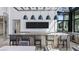 Modern bar area with counter seating, pendant lighting, and a double wall-mounted television at 4450 E Brusca Ct, Pahrump, NV 89061