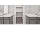 Bathroom featuring double vanity sinks with gray cabinets and a walk-in closet at 4450 E Brusca Ct, Pahrump, NV 89061