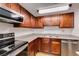 Well-lit kitchen features stainless steel appliances, granite countertops, and updated wood cabinets at 5240 Indian River Dr # 273, Las Vegas, NV 89103