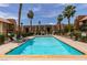 Community pool surrounded by lush landscaping and palm trees at 5240 Indian River Dr # 273, Las Vegas, NV 89103