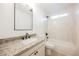 Updated bathroom with granite counters, modern fixtures, and shower over tub with tiled walls and window at 6330 Spring Meadow Dr, Las Vegas, NV 89103
