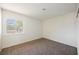 Bright bedroom featuring neutral carpet, fresh paint, and a window offering natural light and neighborhood views at 6330 Spring Meadow Dr, Las Vegas, NV 89103