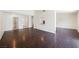 Open living room boasts hardwood floors, neutral paint, and natural light from a serving hatch to the kitchen at 6330 Spring Meadow Dr, Las Vegas, NV 89103