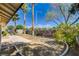 Spacious backyard offers mature trees and shrubs, gravel landscaping, and a concrete patio area at 6521 Faith Peak Dr, Las Vegas, NV 89108