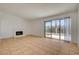 Open living room featuring tile flooring, a cozy fireplace, and sliding glass doors to the backyard at 6521 Faith Peak Dr, Las Vegas, NV 89108