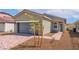 Charming single-story home featuring a two-car garage, small tree, and sidewalk at 6761 Violet Cascade Ave, Las Vegas, NV 89156