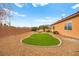 Desert landscaped backyard with manicured lawn and access to the outdoor living space at 7119 Wolf Rivers Ave, Las Vegas, NV 89131
