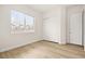 Bedroom featuring a window and closet with wood laminate flooring at 7119 Wolf Rivers Ave, Las Vegas, NV 89131
