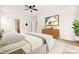 Staged bedroom with modern decor, wood-look floors, and doorway leading to the bathroom at 7119 Wolf Rivers Ave, Las Vegas, NV 89131