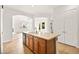 Open kitchen featuring an island with sink, wood cabinetry, and tile flooring, with views into adjoining rooms and outdoor spaces at 7119 Wolf Rivers Ave, Las Vegas, NV 89131