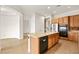 Kitchen with wood cabinets, an island with bar seating, black appliances, and recessed lighting, offering functionality at 7119 Wolf Rivers Ave, Las Vegas, NV 89131