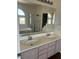 Bright bathroom featuring a double sink vanity, large mirror, bathtub and glass-enclosed shower at 7228 Chic Ave, Las Vegas, NV 89129