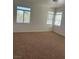 Large bedroom with neutral walls and carpet, and several bright windows at 7228 Chic Ave, Las Vegas, NV 89129