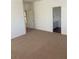 Bedroom with neutral walls and carpet, leading to a bathroom at 7228 Chic Ave, Las Vegas, NV 89129