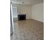 Bright living room featuring a stone fireplace and neutral tile flooring throughout the space at 7228 Chic Ave, Las Vegas, NV 89129
