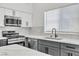 Bright kitchen featuring gray cabinets, white countertops, stainless steel appliances, and wood-look flooring at 831 Purple Sage Ter, Henderson, NV 89015
