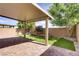 Relaxing backyard with covered patio, artificial turf, and flowering shrubbery at 9035 Drummer Bay Ave, Las Vegas, NV 89149