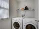 Bright laundry room with washer, dryer, and shelving at 9035 Drummer Bay Ave, Las Vegas, NV 89149
