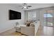 Bright living room featuring a comfortable sectional couch, ceiling fan, and sliding glass doors at 9035 Drummer Bay Ave, Las Vegas, NV 89149