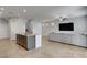 Open living space with a kitchen island and bar stools that leads into the living room with a sectional at 9035 Drummer Bay Ave, Las Vegas, NV 89149