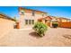 Backyard featuring desert landscaping, a covered patio, and a two-story home under a clear blue sky at 9271 Martel Ave, Las Vegas, NV 89148