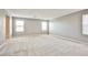 Large bedroom with neutral carpet, three windows, and access to another room at 9271 Martel Ave, Las Vegas, NV 89148