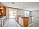 Modern kitchen features granite countertops, stainless steel appliances, and sliding glass door to backyard at 9271 Martel Ave, Las Vegas, NV 89148