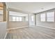 Open living room area with grey wood-look floors and windows at 9271 Martel Ave, Las Vegas, NV 89148