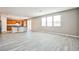 Open concept living room and kitchen area with grey wood-look floors and ample natural light at 9271 Martel Ave, Las Vegas, NV 89148