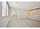 Open living room area with grey wood-look floors and windows at 9271 Martel Ave, Las Vegas, NV 89148