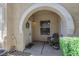 Inviting front porch with a charming archway, chair and potted flowers creating a warm welcome at 10001 Peace Way # 1250, Las Vegas, NV 89147