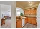 Well-lit kitchen featuring wood cabinets, granite countertops, and open access to the living area at 10001 Peace Way # 1250, Las Vegas, NV 89147