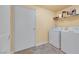 Cozy laundry room with washer, dryer, and overhead shelving for efficient storage at 10001 Peace Way # 1250, Las Vegas, NV 89147