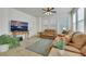 Bright living room features neutral tile flooring, leather sofas, and a large TV at 10001 Peace Way # 1250, Las Vegas, NV 89147