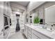 Bathroom featuring dual sinks, white cabinetry, and tiled shower at 101 Mirage View Dr, Henderson, NV 89011
