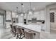 Stylish kitchen featuring a large island with marble countertops, pendant lighting, and white cabinets at 101 Mirage View Dr, Henderson, NV 89011