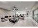Open living room with a large gray sofa, modern fan, and view of the modern white kitchen at 101 Mirage View Dr, Henderson, NV 89011