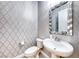 Stylish powder room with patterned wallpaper and a decorative mirror above the sink at 101 Mirage View Dr, Henderson, NV 89011