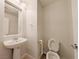 Bathroom with pedestal sink, mirror, toilet, and tile flooring at 10469 Mulvaney Cir, Las Vegas, NV 89141