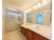 An ensuite bathroom featuring a double sink vanity and glass shower at 10469 Mulvaney Cir, Las Vegas, NV 89141