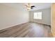 A naturally lit bedroom featuring hardwood floors, a ceiling fan and neutral color palette at 10469 Mulvaney Cir, Las Vegas, NV 89141