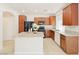Well-lit kitchen featuring an island, granite countertops, wooden cabinetry, and modern, black appliances at 10469 Mulvaney Cir, Las Vegas, NV 89141